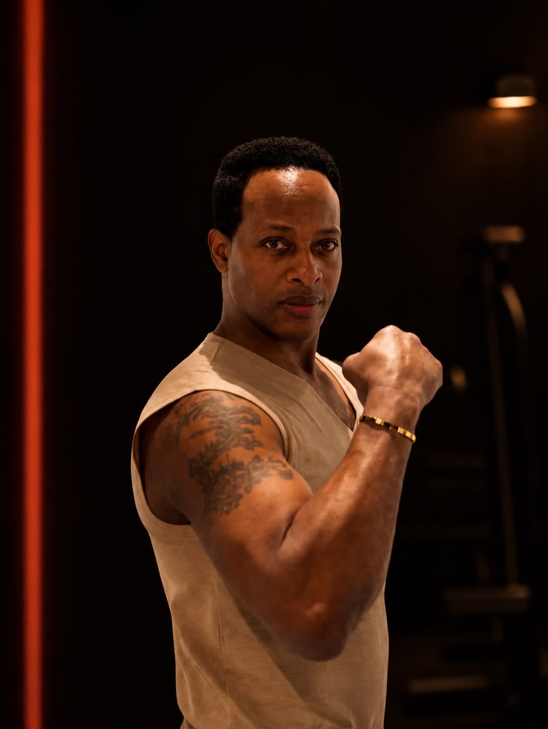 Coach Harold Clark in a fighting stance with his fist raised, in his private gym in Hellerup