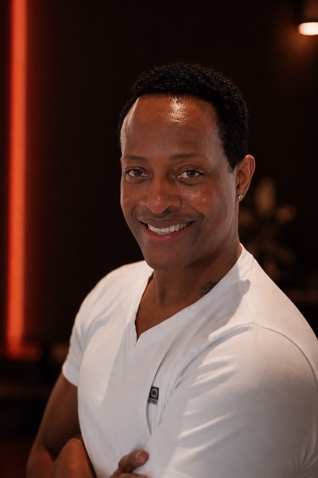 Coach Harold Clark smiling with his arms crossed